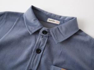 Close-up of blue corduroy shirt featuring ribbed texture and collar label detail