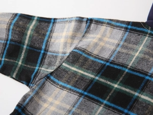 Détail de la couture d'épaule sur une chemise à carreaux en coton pour enfant