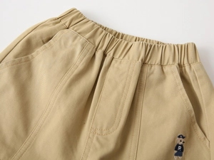 Detail of kids twill cotton trousers showing elastic waistband and bear embroidery