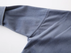 Detail of blue waffle knit fabric showing premium stitching and soft texture on shirt