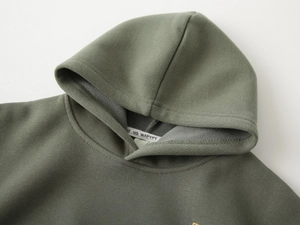 Close-up of olive green hoodie showing warm fleece lining and neckline stitching details