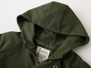 Detail of child's dark green hooded jacket with zipper and premium fabric label