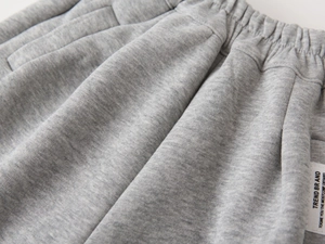 Vista dettagliata della vita elastica e della trama in maglia grigia dei pantaloni bimbo
