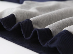 Detail view of boys fleece sweatshirt featuring grey and navy blue ribbed elastic cuffs