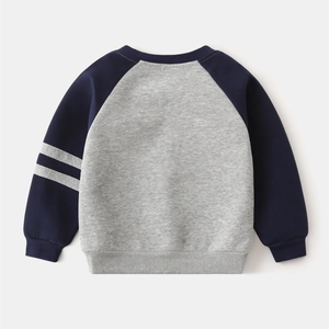 Détail d'un sweat pour enfant avec manches raglan contrastées et poignets en coton côtelé