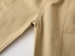 Macro shot of reinforced seams and pocket detail on khaki twill casual pants
