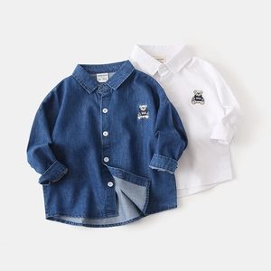 Flat lay of boys' denim and white cotton shirts with bear embroidery detail