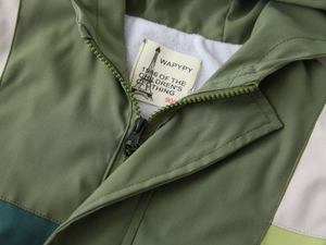 Close-up of zip-up hooded jacket collar with soft fleece lining and high-quality resin zipper