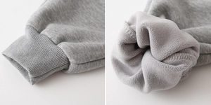 Dettaglio dei pantaloni sportivi grigi per bambini con polsini a coste e fodera in pile