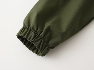 Detail view of elastic ribbed cuff on children olive green canvas jacket with fine stitching