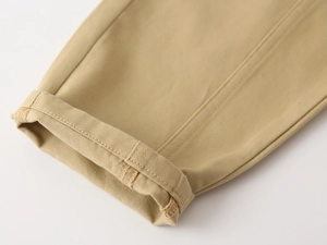 Detail of khaki twill cotton pants featuring double-needle stitching and rolled cuffs