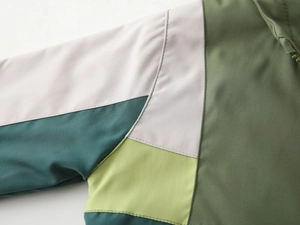 Close-up of waterproof color-block fabric with double stitching on a hooded jacket