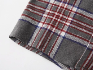 Macro shot of grey plaid flannel fabric with neat double-needle stitching and texture