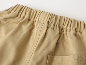 Detail view of khaki cotton twill pants featuring an elastic waistband and back pocket