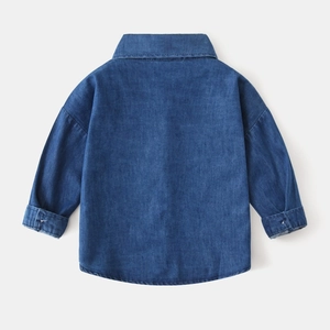Detail view of the back of a blue denim boys' shirt with neat stitching and turn-down collar