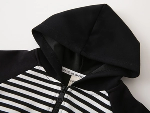 Detail of kids striped patchwork hoodie featuring white logo webbing and durable zipper