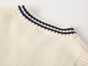Close-up of beige knit vest neckline with navy blue stripes in preppy style