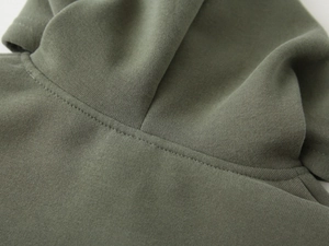 Detailed close-up of double stitching on army green thick cotton fleece hoodie collar