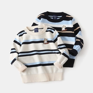 Close-up of children's striped knit sweater featuring cute surfing bear embroidery detail