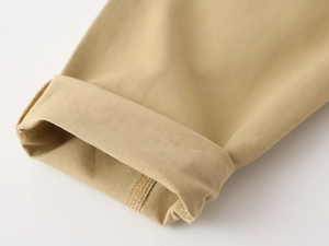 Detail of khaki cotton twill pants showing the neat hem stitching and fabric texture