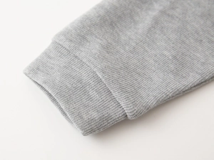 Detail of gray ribbed cuffs on a children's faux two-piece sweatshirt made of soft cotton
