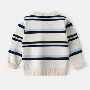 Close-up of cream knit sweater showing blue and black stripes and ribbed texture