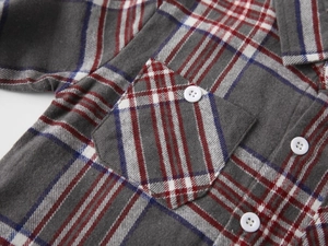 Close-up of boys brushed plaid shirt detail with chest pocket and white button