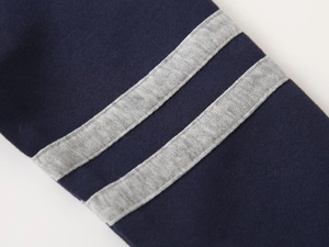 Détail du tissu en maille bleu foncé avec des rayures décoratives grises parallèles