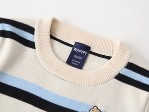 Detail of children's striped knit sweater showing ribbed neckline and bear embroidery