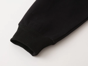 Close-up of black ribbed knit cuffs and high-quality cotton fabric on children hoodie