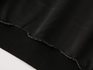 Macro shot of durable ribbed cuffs and precision interior stitching on kids black hoodie
