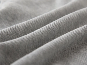 Detailed macro view of the soft grey ribbed cotton fabric and knitted texture on sweatshirt