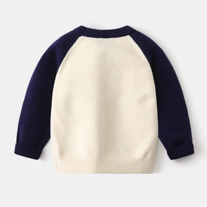 Detail of raglan sleeves and ribbed cuffs on a white and purple knitted baby sweater