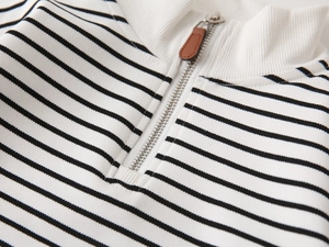 Macro detail of striped kid sweatshirt with metal zipper and brown leather puller