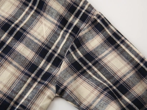 Macro view of blue flannel plaid fabric showing fine stitching and soft texture