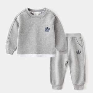 Détail d'ensemble sweat et jogging gris pour enfant avec écusson brodé style collège