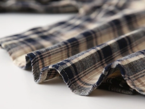 Macro detail of blue and beige plaid cotton flannel fabric with fine stitching