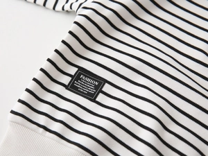 Detail of black and white striped fabric with a fashion patch and ribbed cuff texture