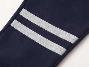 Détail des poignets en tricot bleu marine avec double rayure grise et texture douce