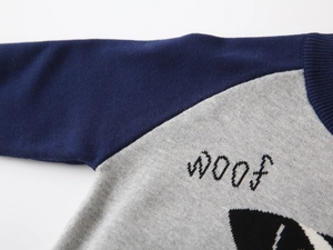Close-up of knit neckline and dog graphic with WOOF text on kids sweater
