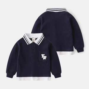 Detailed view of navy waffle knit polo shirt with mock layered hem and letter patch