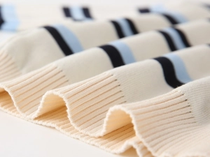 Detailed macro view of soft ribbed knit texture with navy and light blue stripes