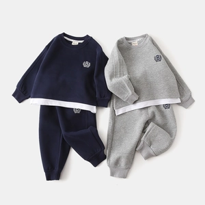 Détail de l'écusson brodé B sur l'ensemble de jogging pour enfant bleu marine et gris