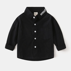 Detail view of black kids' shirt with white Sunday embroidery on the collar and contrast buttons