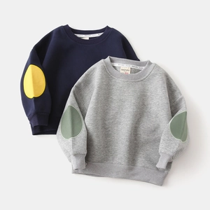 Detail of child sweatshirt showing elbow patches and ribbed cuffs on stacked tops