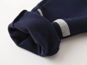 Vue détaillée des poignets en tricot bleu marine avec rayures grises et coutures solides
