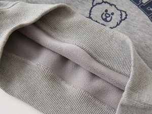 Detail of soft fleece lining and ribbed cuffs on kids' grey cartoon bear sweatshirt