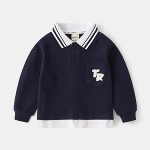 Detailed view of kids navy polo shirt featuring waffle texture and white layered hemline