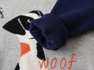 Detailed macro view of the knitted gray fabric with orange dog motif and navy blue cuff