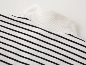 Macro detail of the white ribbed collar and black striped knit fabric on children sweatshirt